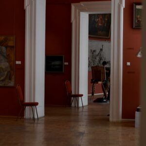 a living room with red walls and white columns